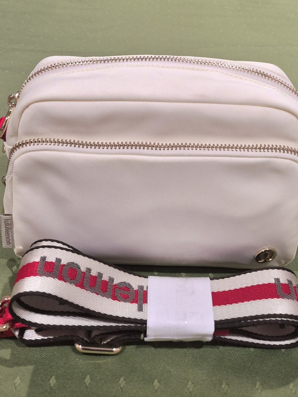 Lululemon CREAM/RED Stripe Monogram Logo on Strap Crossbody Bag, Volum 2L.